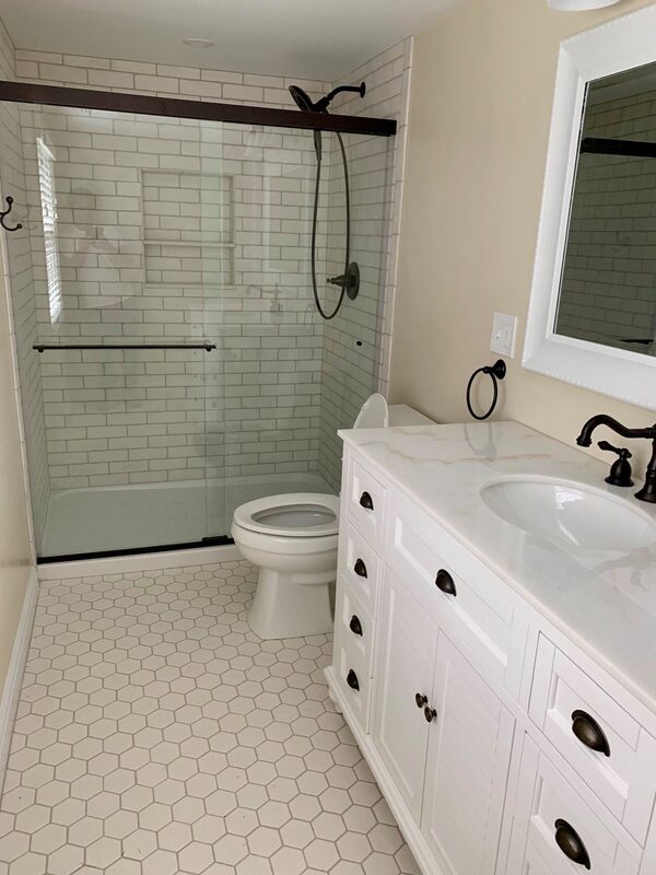 Complete bathroom remodel with white tile and vanity