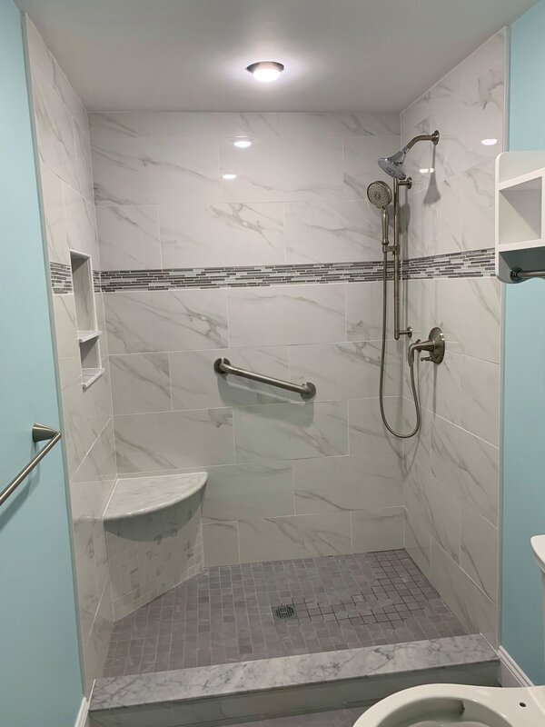 Updated walk in marble shower with decorative tile details