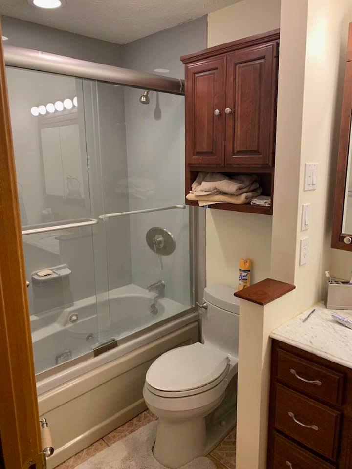 Outdated shower and cabinets in bathroom before remodel